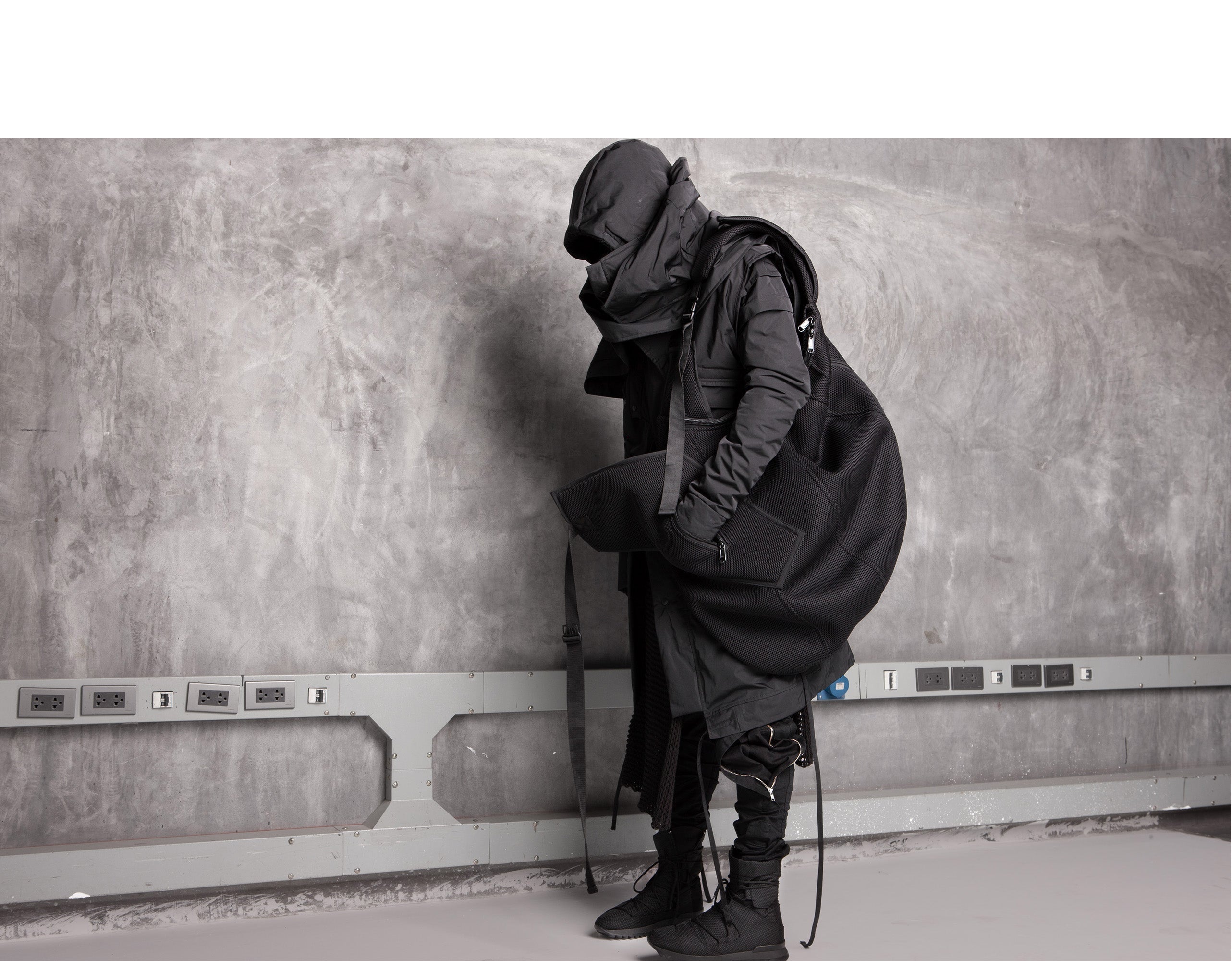 Minimalist futuristic clothing by DEMOBAZA featuring layered black architectural silhouette